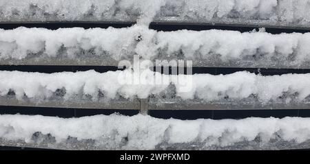 metal car grille covered with ice and snow Stock Photo
