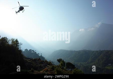 Helicopter flying over green Himalaya mountains from Tenzing–Hillary Airport in Lukla, Nepal Stock Photo