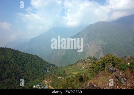 Small propeller airplane flying from Tenzing–Hillary Airport in Lukla on background of green Himalaya Mountains, Nepal Stock Photo