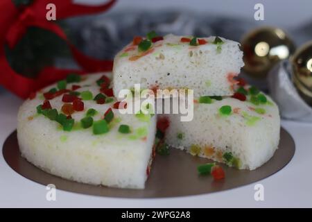 Vattayappam with tutti fruity, a Kerala sweet dish. Vattayappam is a steamed rice cake with coconut and yeast. Tutti fruity are candied fruits. Shot o Stock Photo