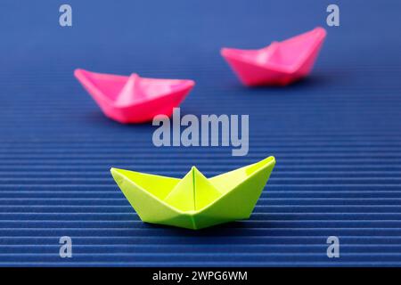 Paper boats where one can be differentiated by color Stock Photo