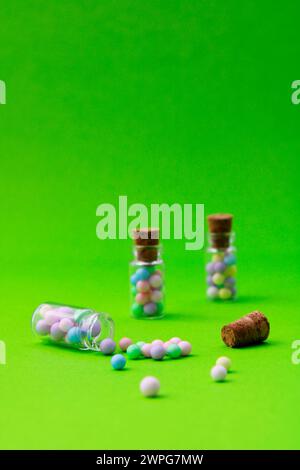 Three glass jars where one of them is open and colorful spheres coming out of it Stock Photo