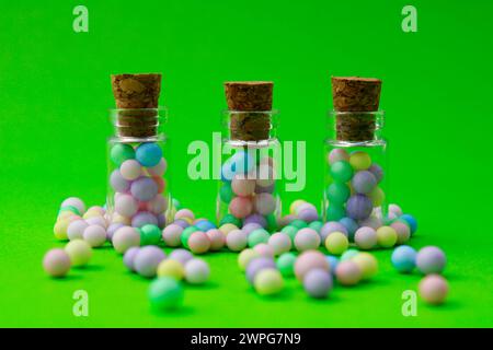 Three glass jars with colorful spheres inside and outside them Stock Photo