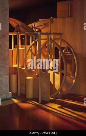 Image of an old wooden machinery structure, subtly illuminated, highlighting its design and details in a dark environment. Stock Photo