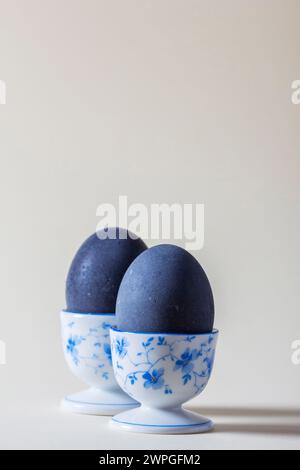 Eggs colored with wine in an egg cup on a light background. Easter concept. Stock Photo