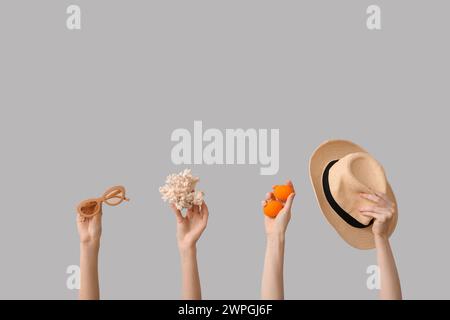 Female hands holding hat with sunglasses, sea coral and Easter eggs on white background. Holiday travel concept Stock Photo