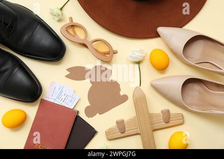 Hat with shoes, passports and Easter decor on yellow background. Holiday travel composition Stock Photo