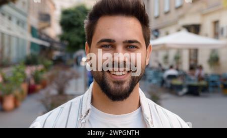 Close up handsome Caucasian European man tourist traveler smiling laughing on city street portrait guy model dental toothy smile happy joyful male Stock Photo