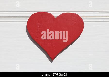 Red wooden heart on white wall background Stock Photo
