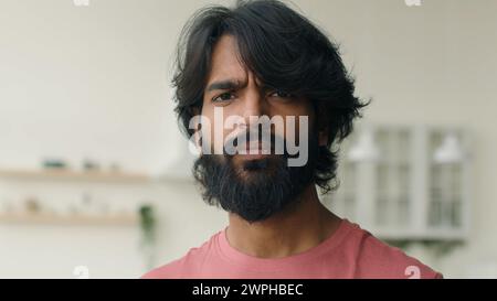 Close up front view adult 30s multiracial Arabian Indian ethnic bearded man serious looking at camera. Male head shot portrait of calm middle-aged Stock Photo