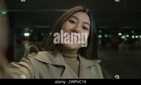 Webcam view POV happy smiling Asian woman girl chinese korean blogger vlogger influencer talking to smartphone camera for social blog channel blogging Stock Photo