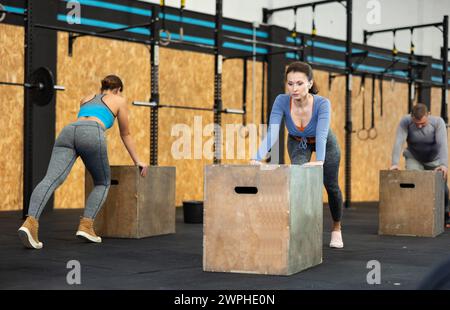 Focused woman doing cross fit in gym. Active training Stock Photo