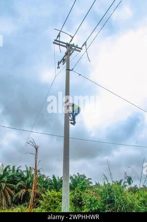 electrician climbs power pole Stock Photo