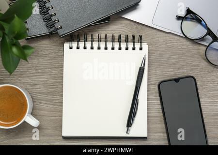 Flat lay composition with notebooks, laptop and smartphone on wooden table Stock Photo