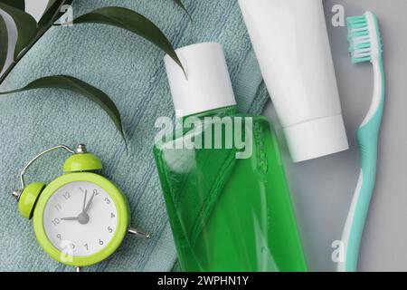 Flat lay composition with fresh mouthwash in bottle and other oral care products on grey background Stock Photo