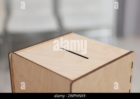 Wooden ballot box on blurred background, closeup Stock Photo