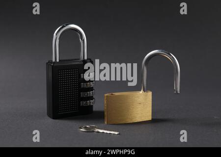 Different padlocks and key on black background, closeup Stock Photo