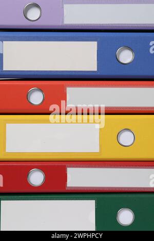 Many bright office folders as background, closeup Stock Photo