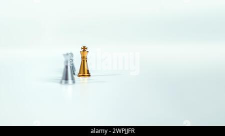 Golden king chess on the board in front of silver chess pieces on white background with copy space, Leadership, fighter, business leadership, competit Stock Photo