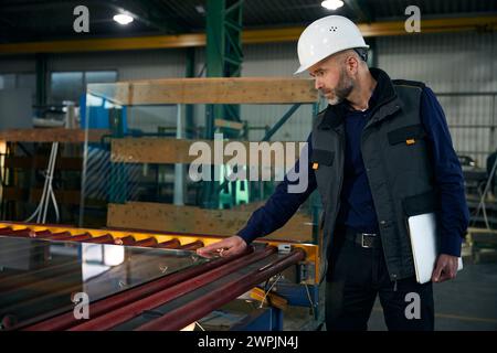 Man with a laptop inspects the material for double-glazed windows Stock Photo