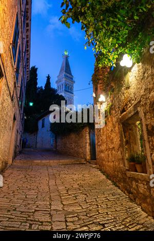 beautiful street of Rovinj Croatia with cobblestone and church tower dusk. Stock Photo