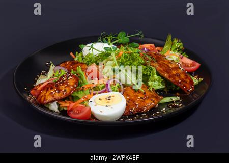 Salad with chicken and croutons, tomatoes, cheese and sauce. Boiled egg. Copy space Stock Photo