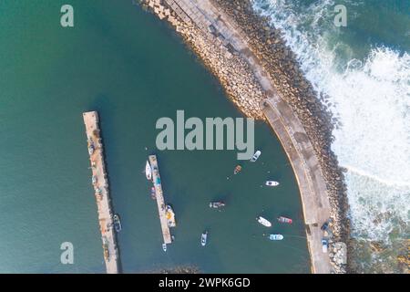 zenithal drone aerial view of a breakwater protecting a fishing port Stock Photo