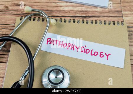 Concept of Pathophysiology write on sticky notes with stethoscope isolated on Wooden Table. Stock Photo