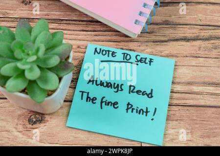 Concept of Note to self - Always Read the Fine Print write on sticky notes isolated on Wooden Table. Stock Photo