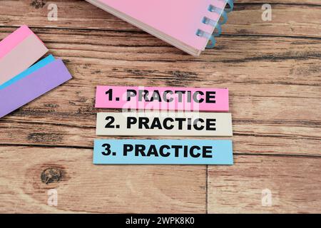 Concept of Practice, Practice, Practice write on sticky notes isolated on Wooden Table. Stock Photo