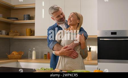 Loving happy family carefree couple adults middle-aged spouses senior man mature woman looking at each other smiling with love bonding affectionate Stock Photo