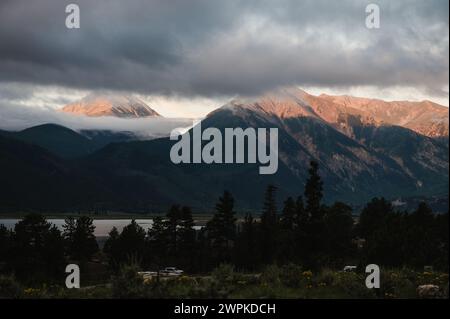Sunlight breaks through clouds over mountain peaks. Stock Photo