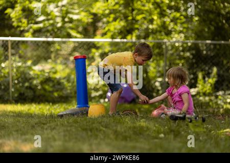 Two kids having a great time playing in their backyard Stock Photo