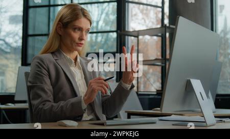Caucasian adult middle-aged business coach entrepreneur tutor mentor woman communicate by video call. Mature businesswoman speaking computer online Stock Photo
