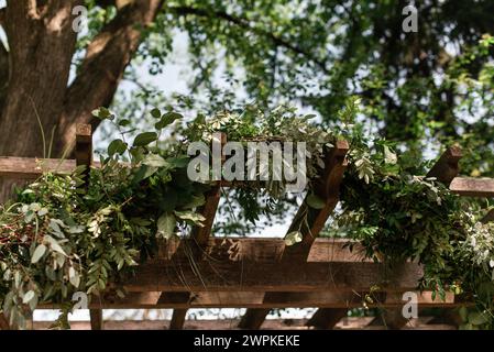 Close up of outdoor pergola decorated with green foliage garland Stock Photo