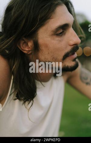Portrait of a young man with long brown hair and dark eyes. Stock Photo
