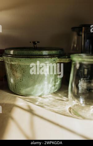 Light from window streams in reflecting off mason jar and dutch oven Stock Photo