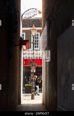 Narrow and claustrophobic, probably very old, access alley path between two shop building / buildings in Banbury, Oxfordshire. UK. (134) Stock Photo
