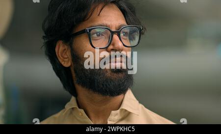 Serious thoughtful Arabian bearded man in glasses in office corporate company thinking looking away Indian pensive businessman manager executive deep Stock Photo