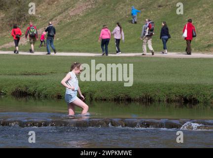 15/04/15  On the hottest day of the year, tourists flock to cool-off as they cross stepping stones crossing the river Dove at Dovedale, near Ashbourne Stock Photo