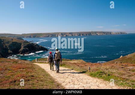 Hikers at Pointe du Van near Saint-They chapel, Trepasses bay and Iroise sea, Cleden-Cap-Sizun, Finistere (29), Brittany, France Stock Photo
