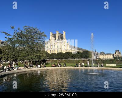 People sitting in the Tuileries Park near the Louvre, Paris, France, Europe Stock Photo
