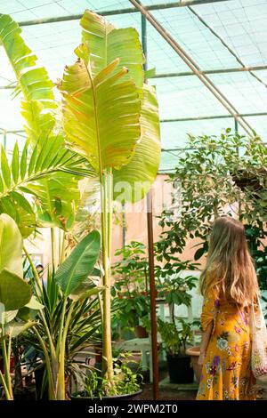 A woman walking through a beautiful botanical garden, a sustainable
