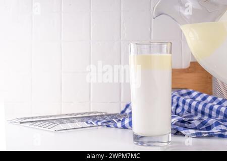 Non-Homogenized, whole milk, cream-top layered dairy product, Creamline Milk concept. Organic farm natural, unpasteurized milk in glass and jug, on wh Stock Photo