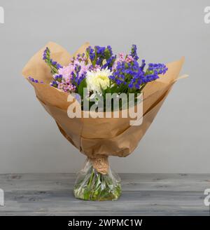 Hand-tied bouquet with water in cellophane for freshness, then wrapped in brown paper Stock Photo
