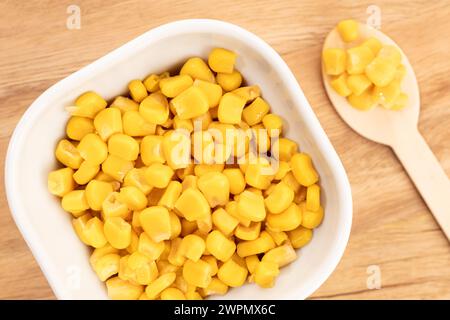 Sweet corn kernels in bowl on wooden table still life Stock Photo