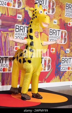 London, UK. March 2nd, 2024.   (EDITORIAL USE ONLY. NO PUBLICATIONS DEVOTED EXCLUSIVELY TO THE ARTIST) Rob Beckett dressed in a plastic giraffe costume while attending the BRIT Awards 2024 at The O2 Arena on March 02, 2024 in London, England. Credit: S.A.M./Alamy Live News Stock Photo