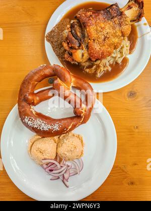 Pretzel and Obazda and knuckle of pork with cabbage served as a Bavarian meal Stock Photo