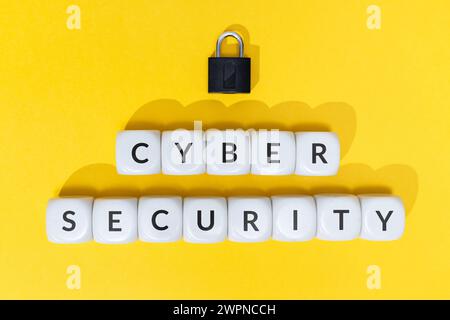 Cyber security concept. Text on blocks and padlock on yellow background Stock Photo