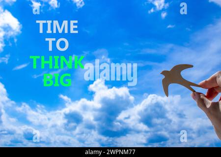 Time to think big symbol. Concept words Time to think big. Beautiful blue sky cloud background. Voter hand with wooden bird. Business and time to thin Stock Photo